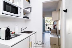 a white kitchen with a sink and a microwave at MADA Charm Apartments Jacuzzi in Vernazza