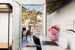 a room with a table with a vase of flowers at MADA Charm Apartments Jacuzzi in Vernazza