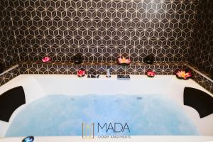 a bath tub in a bathroom with a tiled wall at MADA Charm Apartments Jacuzzi in Vernazza