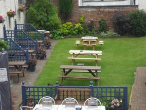 uma mesa de piquenique e bancos num quintal em The London Inn em Cheltenham