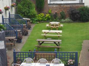 a picnic table and benches in a yard at The London Inn in Cheltenham