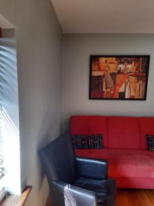 a red couch and a chair in a room at Skellys in Ballymahon