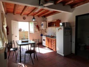 a kitchen with a table and a white refrigerator at Bungalows Jovi in Colón