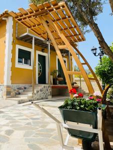 a patio with a wooden pergola and a pot of flowers at Zamor Family Villa 2 in Zakynthos Town