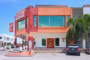 a store front with a car parked in a parking lot at Super OYO 439 Night Queen Hotel in Sepang