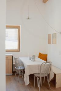 Bergauf Appartement في غروسارل: غرفة طعام مع طاولة بيضاء وكراسي