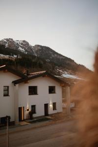 a white house with mountains in the background at Bergauf Appartement in Grossarl
