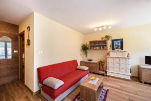 - un salon avec un canapé rouge et une télévision dans l'établissement Casa Rancolin, à Moena
