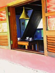 una ventana con vistas a una mesa en Praia do Rosa Kaora Cabanas, en Praia do Rosa