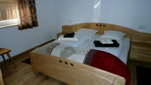 um quarto com uma cama de madeira e 2 almofadas em Ferienwohnung Lejo em Virgen