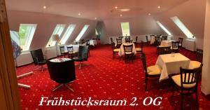 uma sala de jantar com mesas e cadeiras num tapete vermelho em Hotel Seegarten em Barmstedt