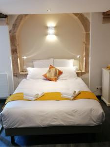 a large white bed with two towels on it at L'antre ami in Savigny-lès-Beaune