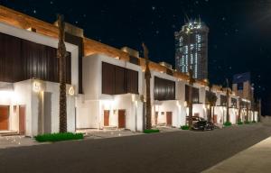 a row of buildings at night with a tall building at Beach Time Villas Hotel in Jeddah