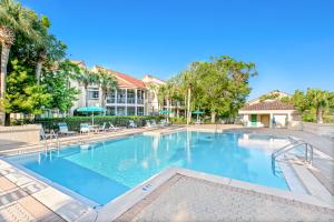 a large swimming pool with chairs and a building at Sunshine Cottage in Destin