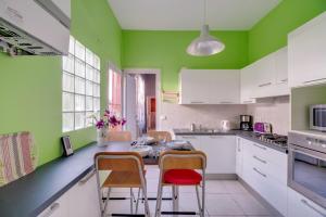 cocina con paredes verdes, mesa y sillas en Aquarelle en Arcachón