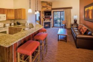 a kitchen and living room with a bar and a couch at Club Wyndham Glacier Canyon in Lake Delton