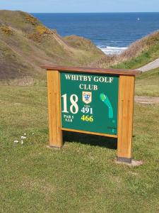 un cartel para un club de golf en la playa en Ellies Guest House en Whitby