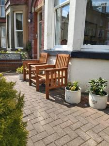 two wooden benches sitting outside of a building at Ellies Guest House in Whitby
