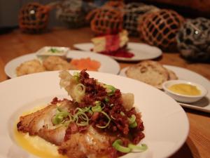Skrova的住宿－Heimbrygga Restaurant & Accommodation，桌上的盘子,和其他盘子的食品