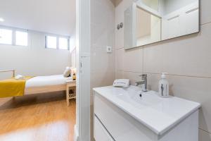 La salle de bains est pourvue d'un lavabo et d'un lit dans la chambre. dans l'établissement GuestReady - Back to Road to Greenhouse, à Porto