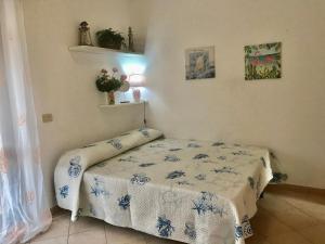 1 dormitorio con 1 cama con manta azul y blanca en Kathy APARTMENT, en Cannigione