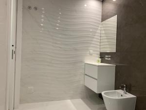 a bathroom with a toilet and a sink and a shower at Apartamentos Quebra-Mar 2 in Nazaré +16 photos
