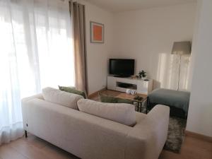 a living room with a couch and a television at Chambre double avec salle de bain commune, a 2 min de la Croisette in Cannes