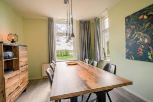 a dining room with a wooden table and chairs at Nieuwlanderweg 55 in De Waal