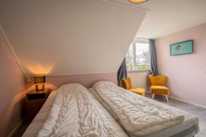 a bedroom with a bed and two chairs at Nieuwlanderweg 55 in De Waal