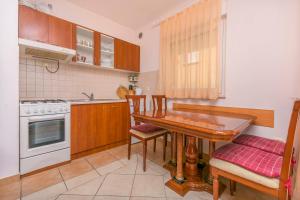 een keuken met een houten tafel en een fornuis bij Apartment Mario in Rogoznica