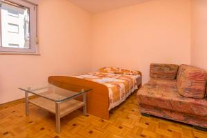 een kleine kamer met een bed en een stoel bij Apartment Mario in Rogoznica