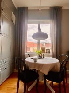 a dining room with a table and a window at lägenhet på innergården in Alingsås