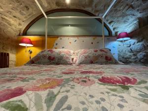 a bedroom with a large bed with flowers on it at Mas Tulsà Casa Rural Girona in Riudellots de la Creu