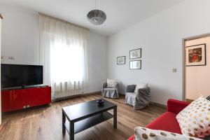 sala de estar con sofá rojo y TV en RomagnaBNB Casemurate, en Casemurate
