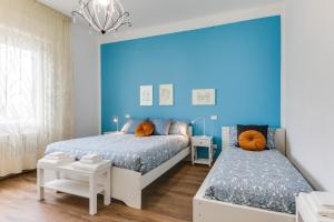 1 dormitorio con 2 camas y pared azul en RomagnaBNB Casemurate, en Casemurate