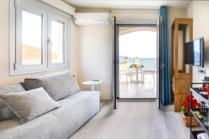 ein Wohnzimmer mit einem Sofa und Meerblick in der Unterkunft Sunrise Bay Apts in Ayia Evfimia