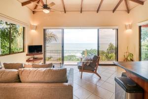 sala de estar con sofá y vistas al océano en Canto del Mar #20, en Dominical