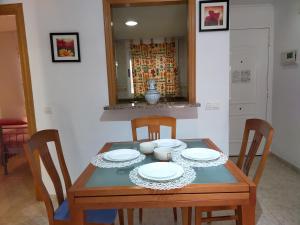 einen Esstisch mit Stühlen und Tellern darauf in der Unterkunft ACV - Isla Park-1ª Linea Planta 1 Sur in Oropesa del Mar