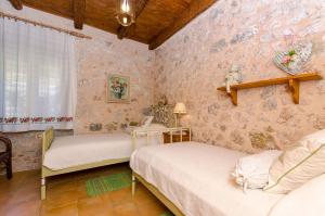 2 Betten in einem Zimmer mit rosafarbener Tapete in der Unterkunft Apartments Peric in Igrane + 38 Fotos