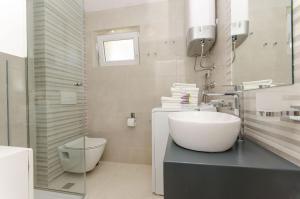 a white bathroom with a sink and a toilet at Apartment Sreta in Omiš +42 photos