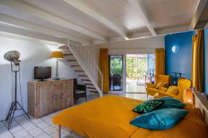 a bedroom with a yellow bed and a staircase at Studio at the pool in tropical Resort Seru Coral with privacy and large pool in Willemstad