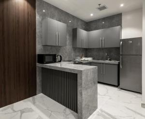 a kitchen with black and stainless steel appliances at Beach Time Villas Hotel in Jeddah