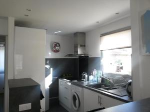 a kitchen with a sink and a washing machine at Chambre double avec salle de bain commune, a 2 min de la Croisette in Cannes