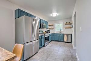 a kitchen with blue cabinets and a refrigerator at Updated Fayetteville Home Less Than 2 Miles to UArk! in Fayetteville