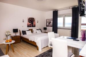 a bedroom with a large bed and a table and chairs at Apartment and Rooms Ana in Podstrana