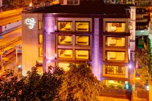 un edificio con luces púrpuras en el lateral. en Hotel Casa Fortuna en Calcuta