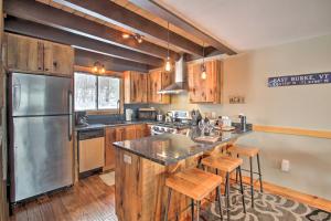 uma cozinha com armários de madeira e um frigorífico de aço inoxidável em Ski-InandOut Burke Mtn Condo with Amenity Access! em East Burke