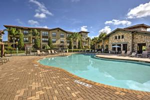 una piscina en un complejo con sillas y un edificio en Davenport Condo with Pool Access - 11 Mi to Disney! en Davenport