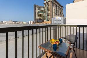 a table with a bowl of fruit on a balcony at Le Wana Hotel in Dubai