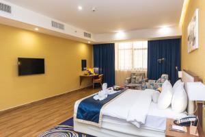 Habitación de hotel con cama y TV en Le Wana Hotel en Dubái